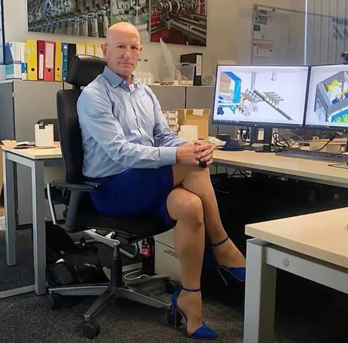 Mark Brayan striking a pose while sitting at his desk at work, Photo Credit: Mam News